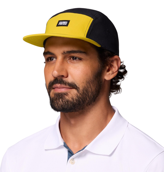 persona usando gorra Columbia Creek Side 5 Panel Hat durante una actividad outdoor negra y amarilla