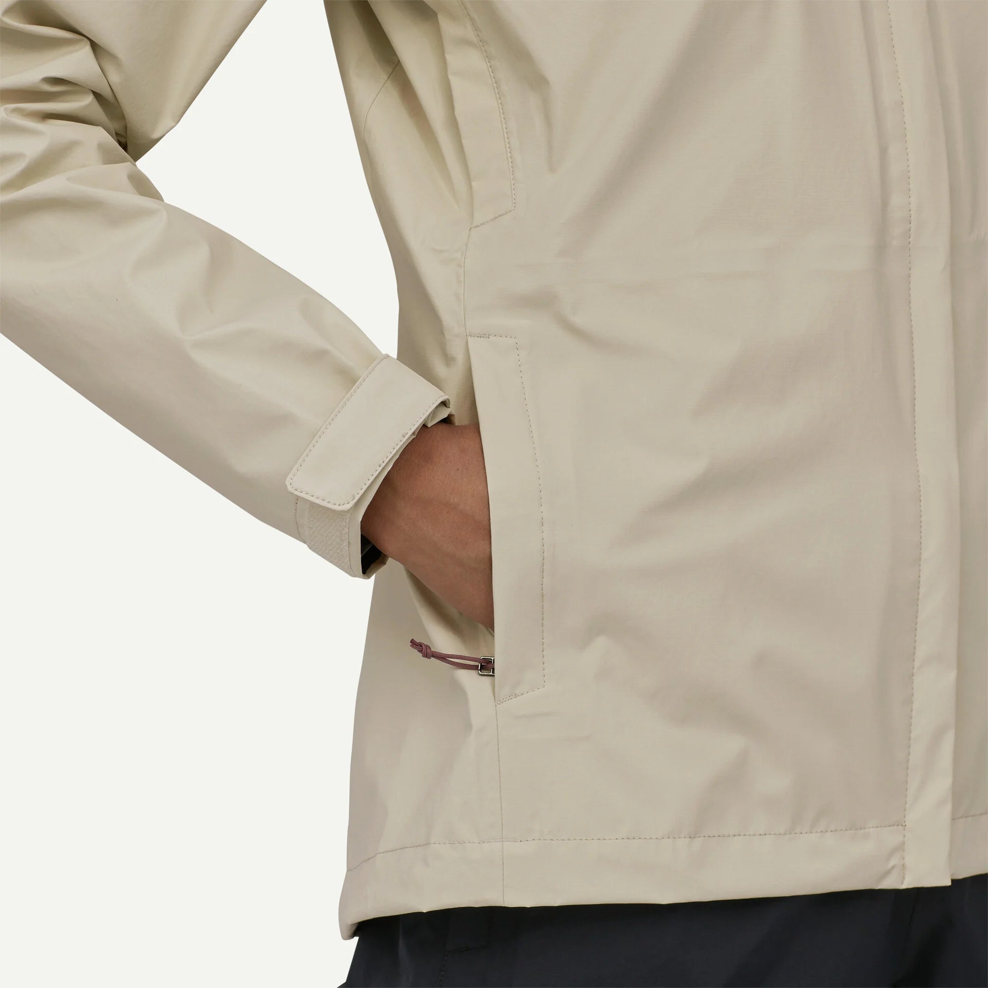 Detalle de los bolsillos de la Patagonia W's Torrentshell 3L Rain Jkt para mujer, prácticos para guardar objetos y proteger las manos blanco
