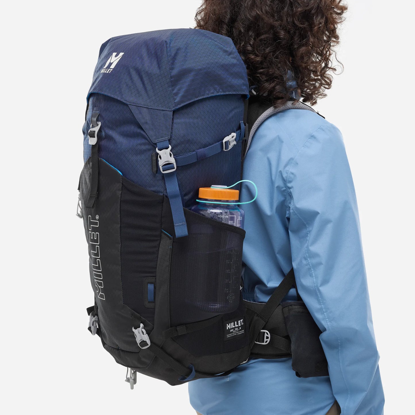 mochila Millet Ubic 30L mujer con botella colocada en el bolsillo lateral