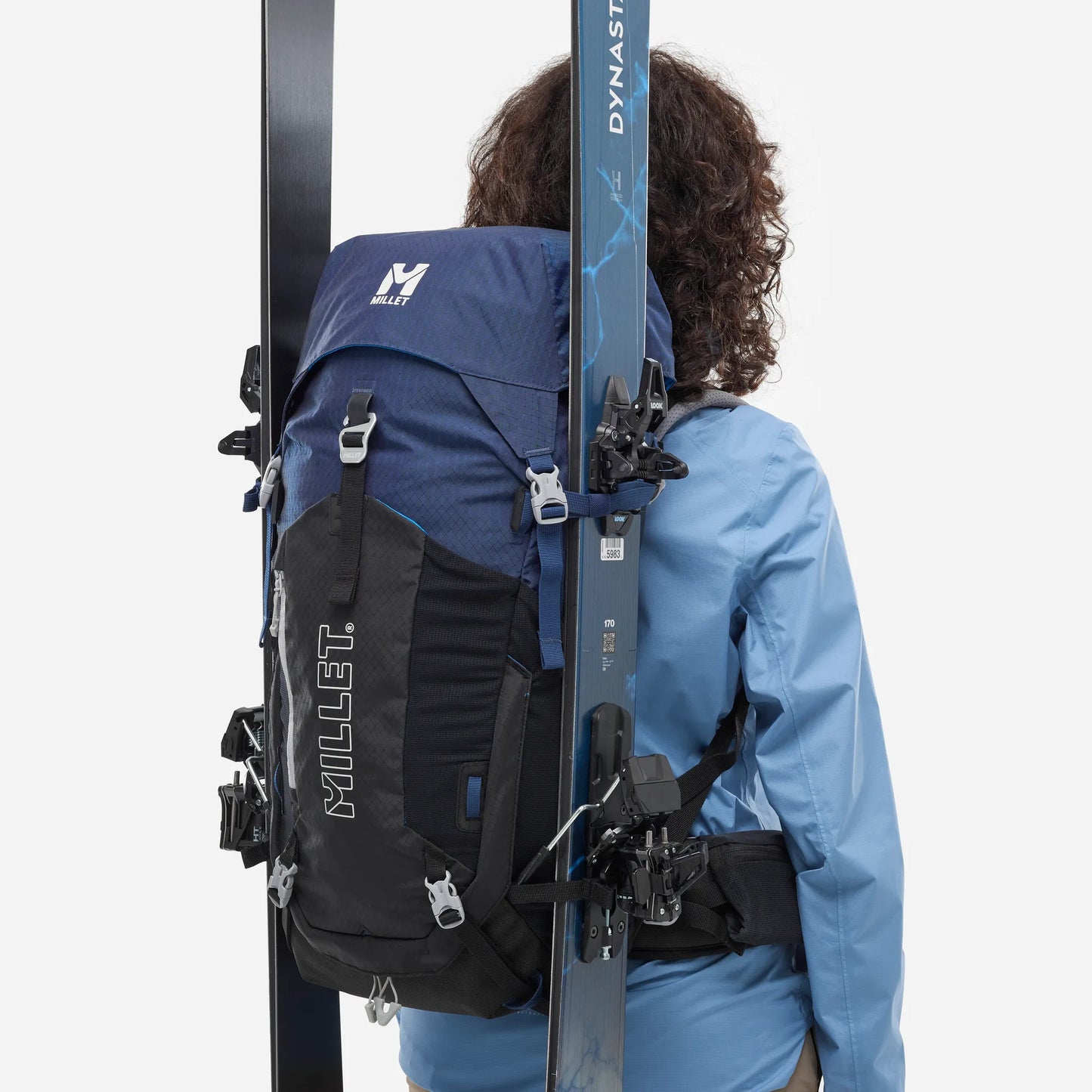 mochila Millet Ubic 30L mujer con esquís de travesía sujetos en el exterior
