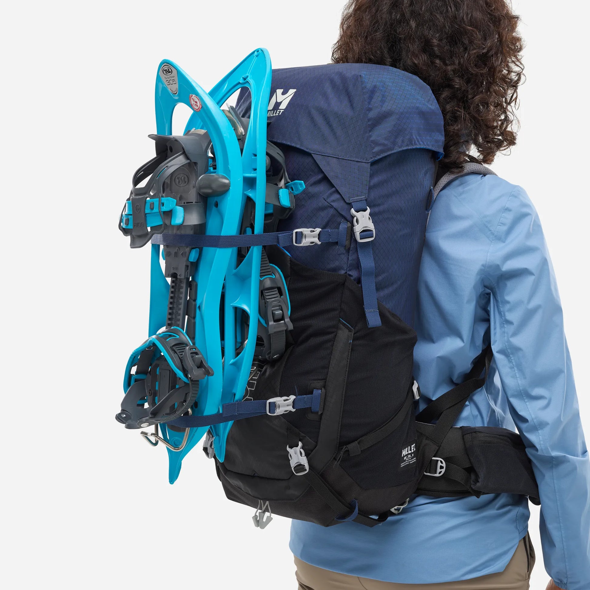 mochila Millet Ubic 30L mujer con raquetas de nieve sujetas en el exterior