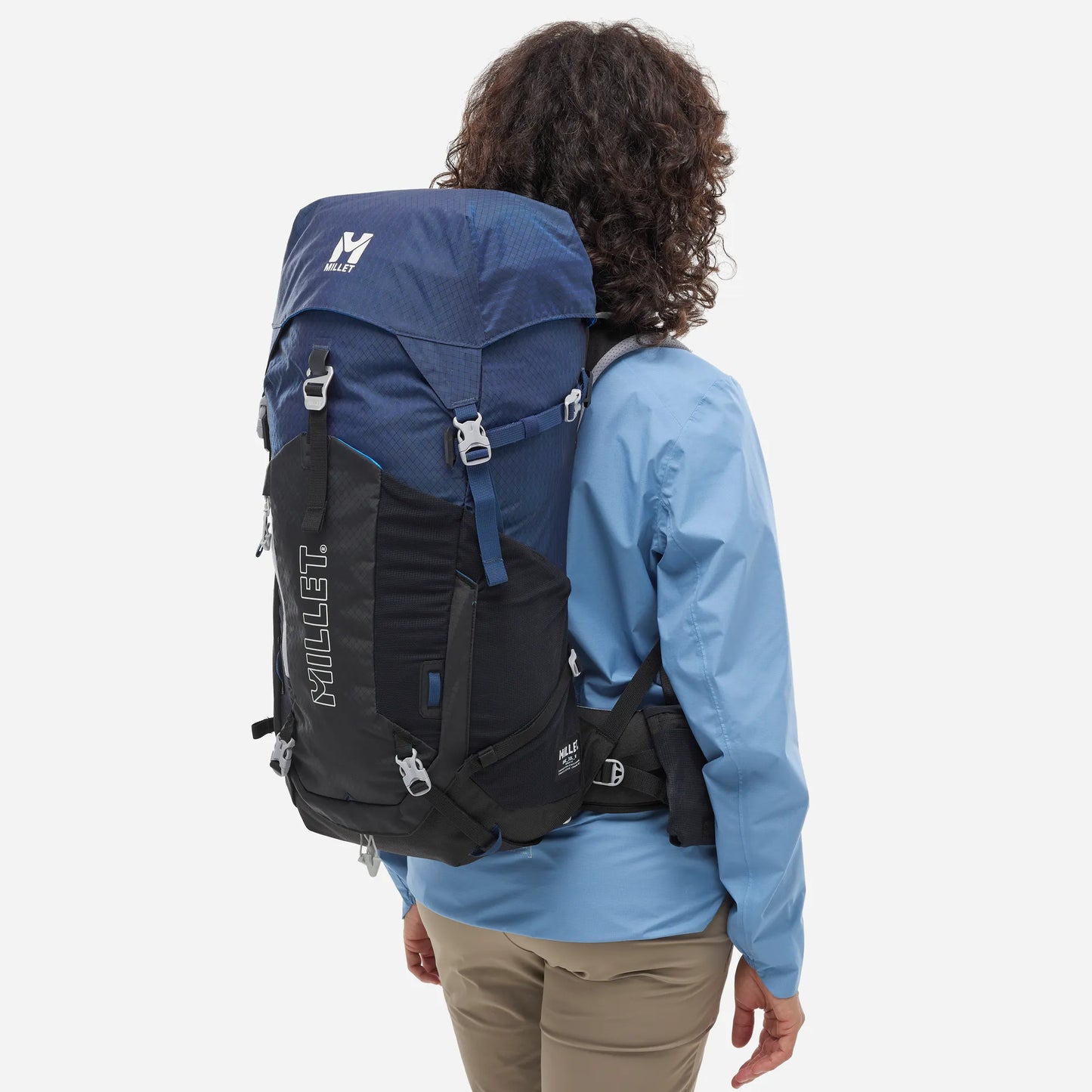 mujer usando mochila Millet Ubic 30L durante una ruta de trekking en montaña