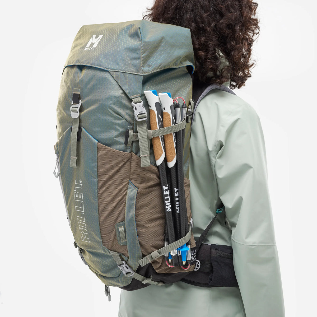 mochila Millet Ubic para mujer con bastones de trekking sujetos en el exterior