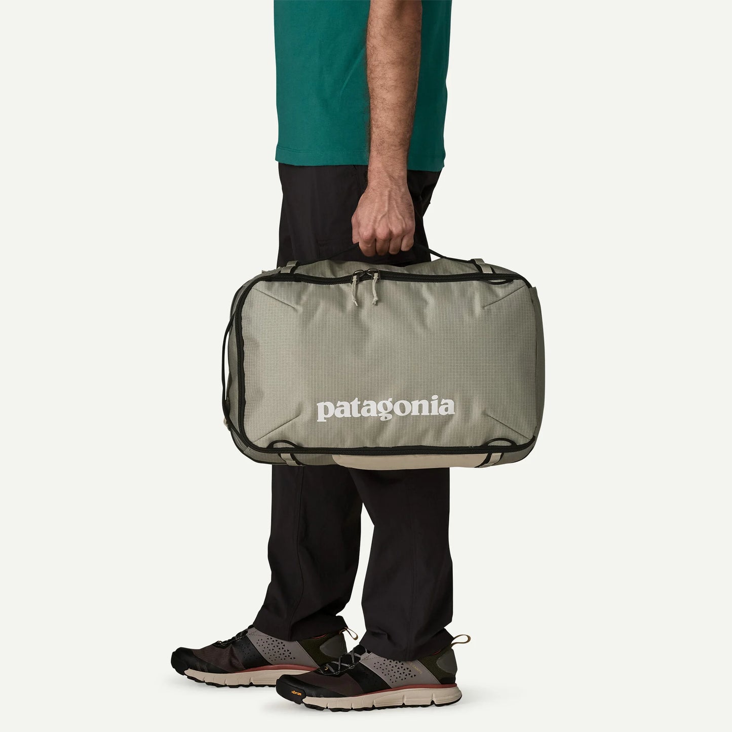 persona llevando Patagonia Black Hole Mini MLC 30L como bolsa de mano durante un viaje