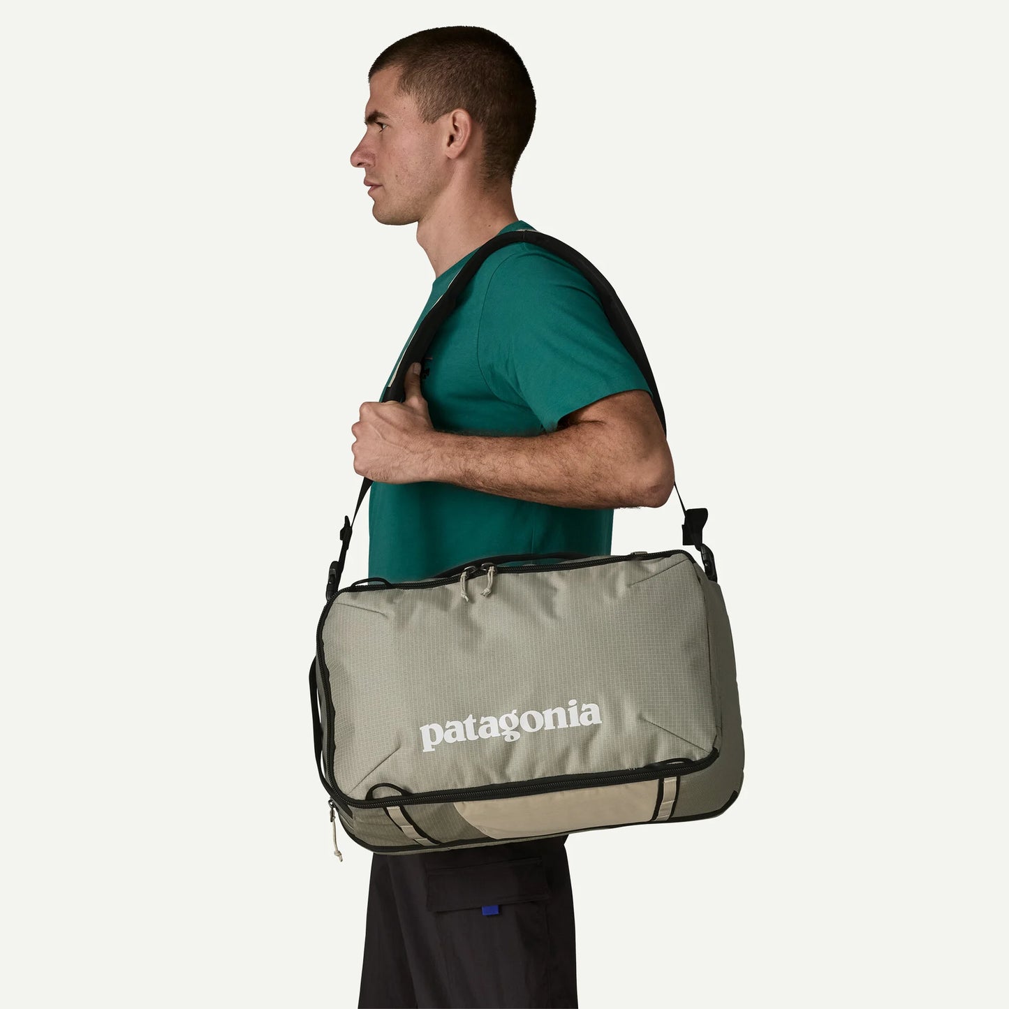 hombre llevando Patagonia Black Hole Mini MLC 30L colgada al hombro como bolsa de viaje