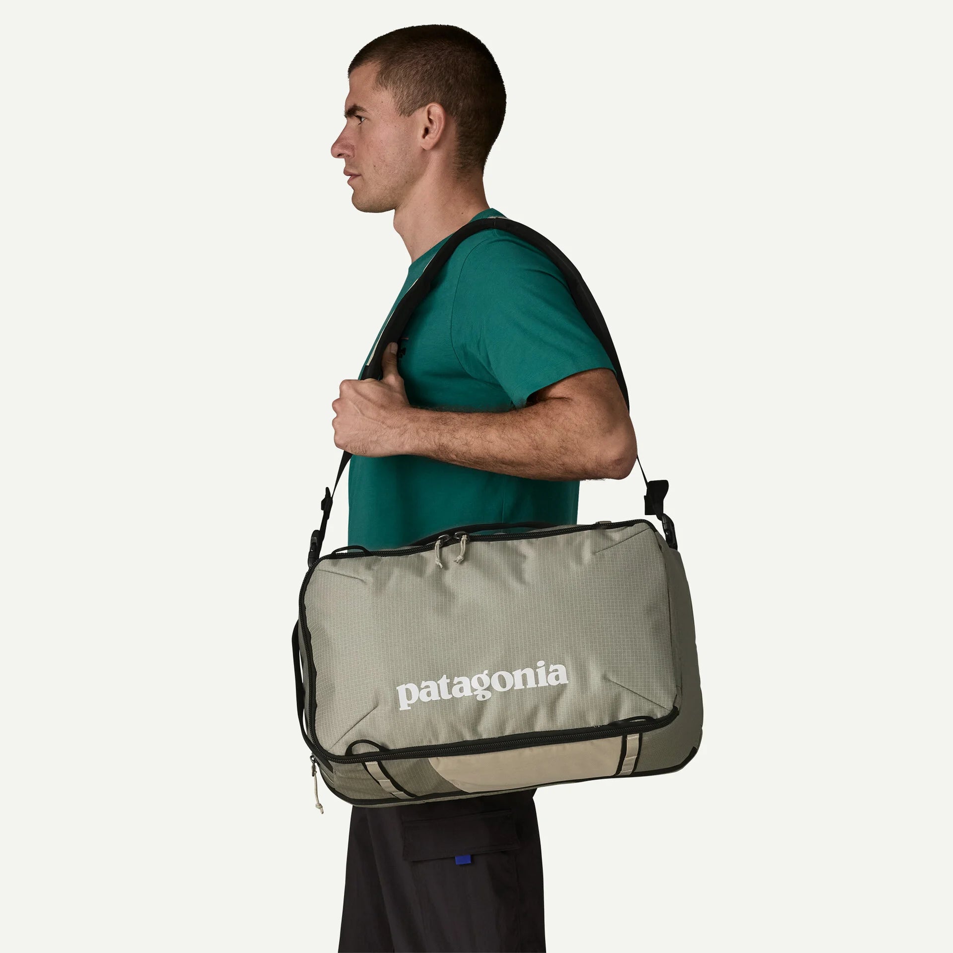hombre llevando Patagonia Black Hole Mini MLC 30L colgada al hombro como bolsa de viaje