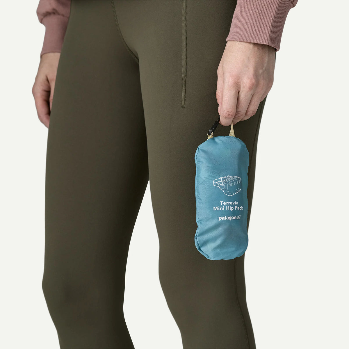 riñonera Patagonia Terravia Mini Hip Pack plegada dentro de su propia bolsa para facilitar el transporte