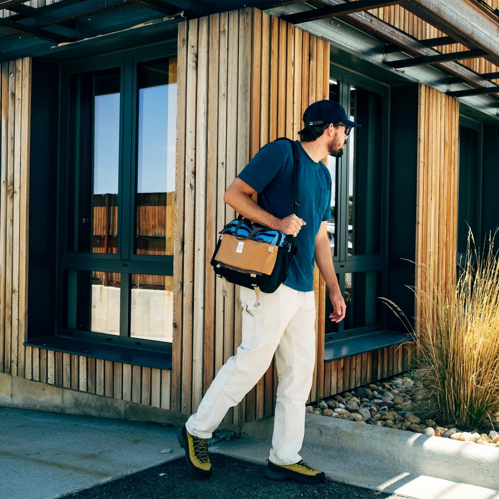 persona llevando Topo Designs Mountain Cross Bag 14L colgada al hombro